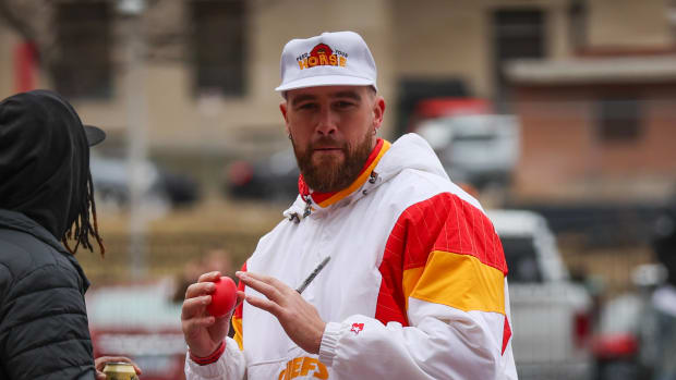 TRavis Kelce sostiene un balón de americano de juguete